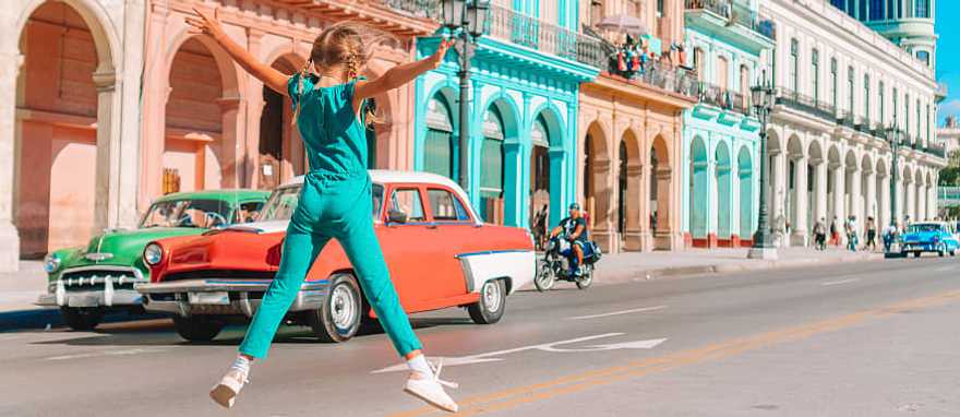 Havana, Cuba Girl in the street with vintage classic American car in old Havana, Cuba