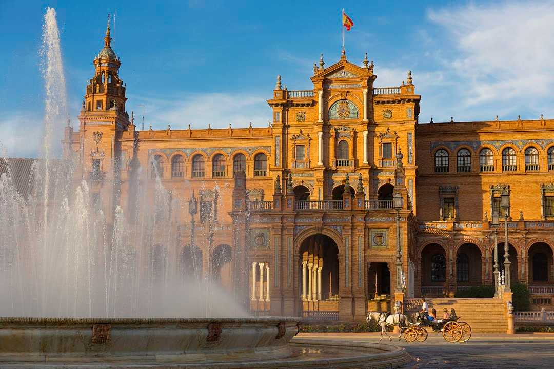 Plaza de España in Seville, Spain, featuring a grand fountain, historic architecture, and a horse-drawn carriage