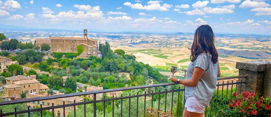 Montalcino in Tuscany, Italy Woman enjoying a glass of wine and the view in Montalcino, Italy