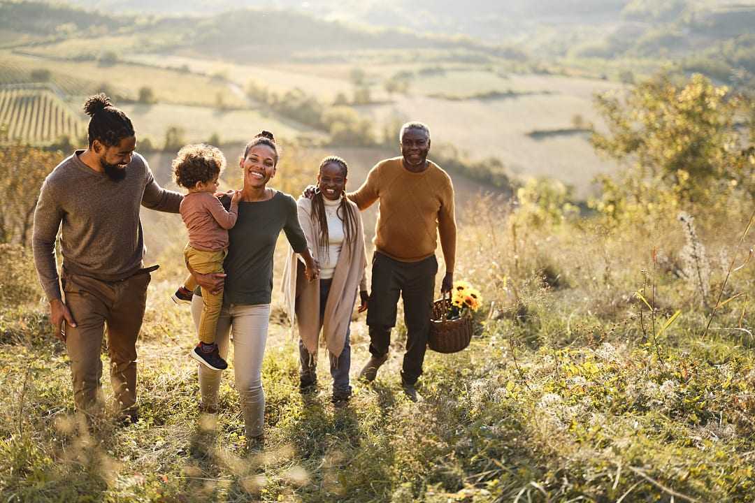 Multi-generational family exploring vineyards during the fall