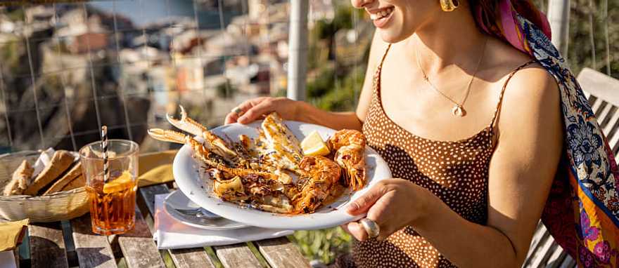 Liguirian cuisine in Vernazza, Italy Woman enjoying Liguirian cuisine outdoors with a view in Vernazza, Cinque Terre, Italy