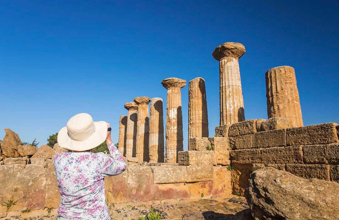 Valley of the Temples in Sicily, Italy Senior woman taking a photograph at the Valley of the Temples in Sicily, Italy