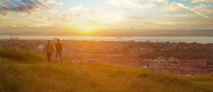 Couple enjoying cityscape at sunset, Edinburgh, Scotland, UK Couple enjoying cityscape at sunset, Edinburgh, Scotland, UK