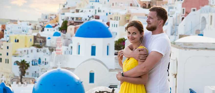 Couple enjoying the view of Santorini Island in Greece Couple enjoying the view of Santorini Island in Greece