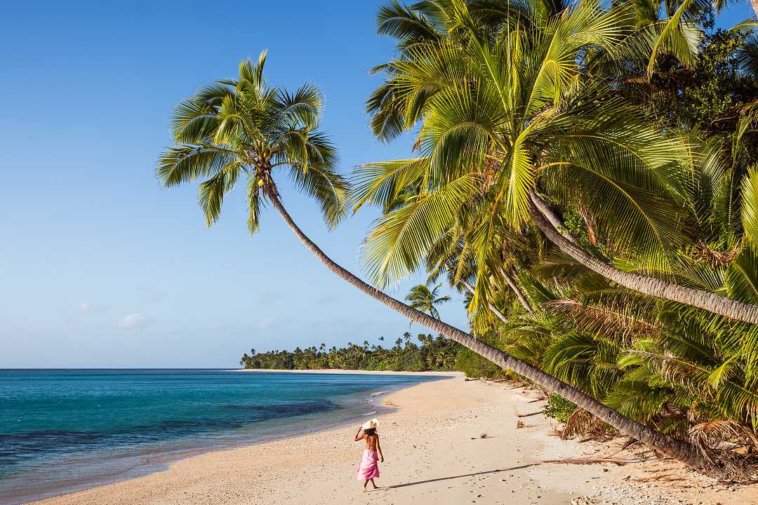 Woman walking the long stretch of beach on Kadavu Isand, Fiji